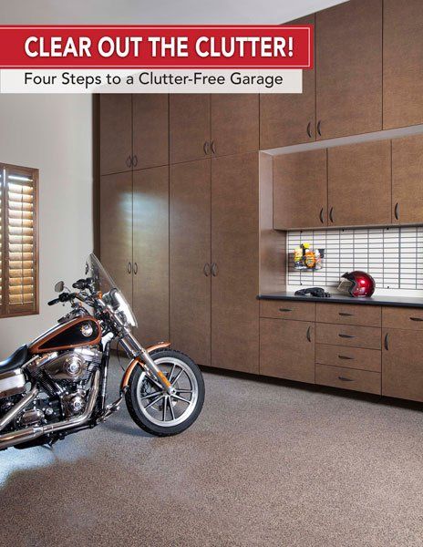 A motorcycle is parked in a garage that says clear out the clutter