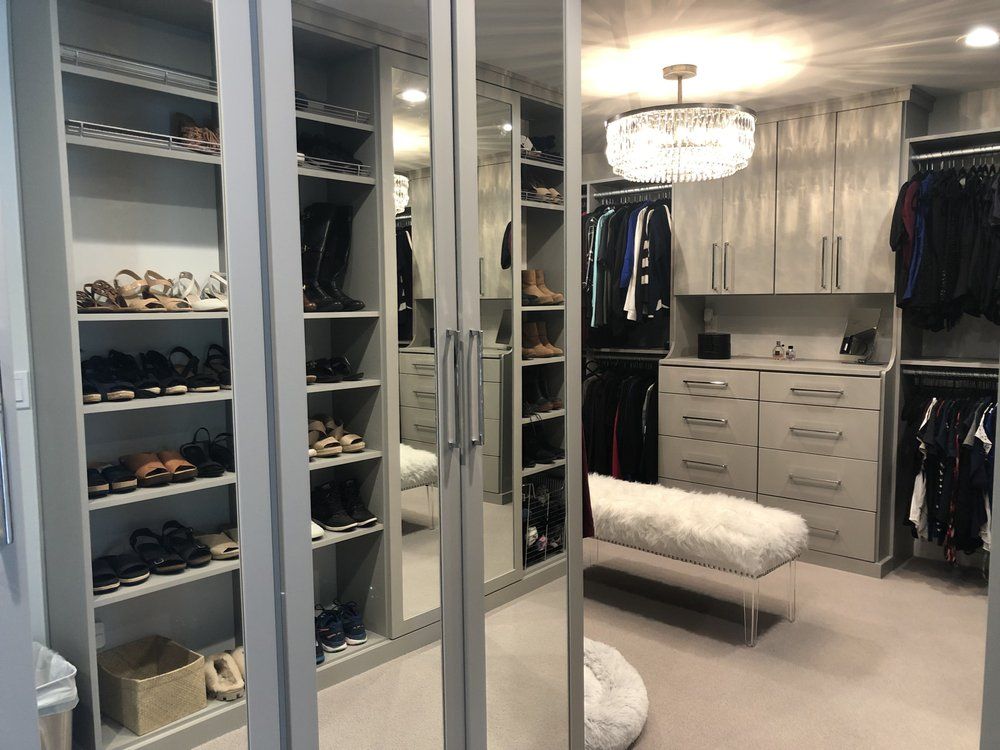 A walk in closet filled with lots of clothes and shoes.