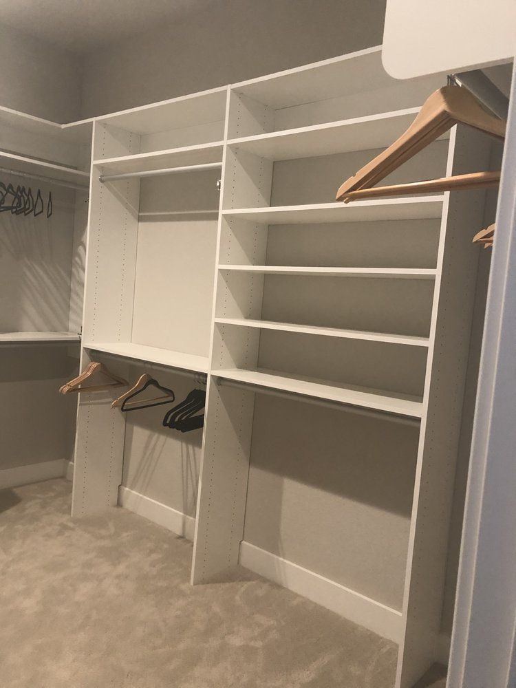 A walk in closet with a lot of shelves and hangers.