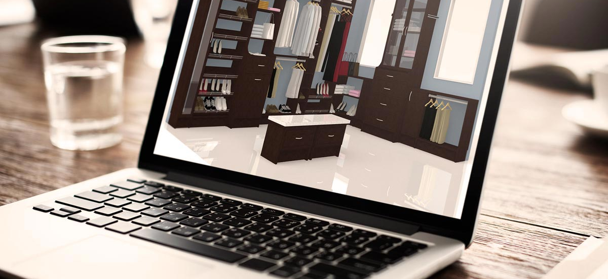 A laptop computer is sitting on a wooden table next to a glass of water.