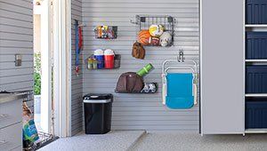 A garage with a lot of shelves and a chair hanging on the wall.