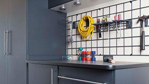There is a hose hanging on the wall in the garage.