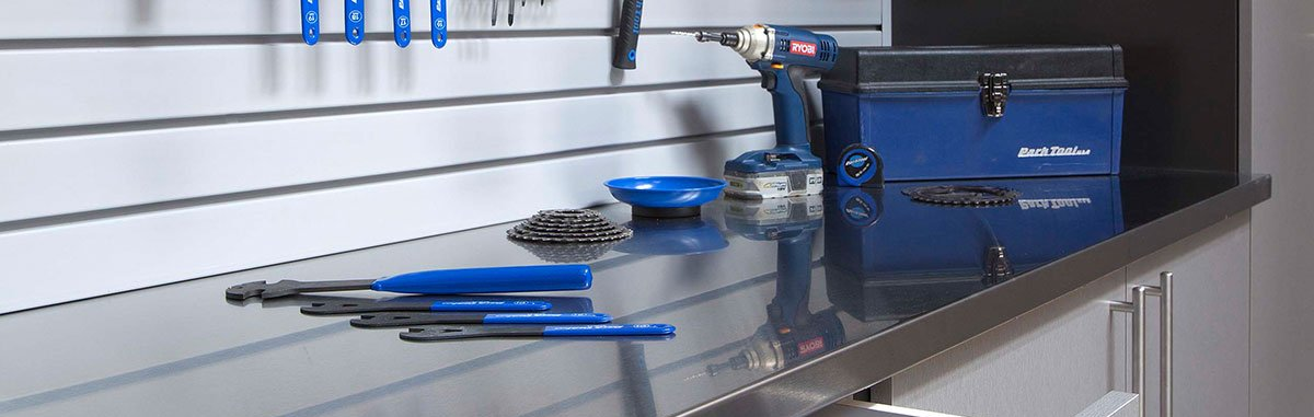 A stainless steel workbench with tools and a drill on it.