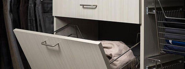 A drawer in a closet with a sweater in it.