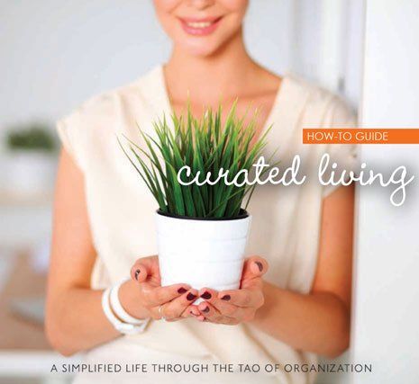 A woman is holding a potted plant on the cover of a book titled curated living