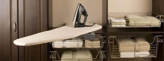 An iron is sitting on top of an ironing board in a laundry room.