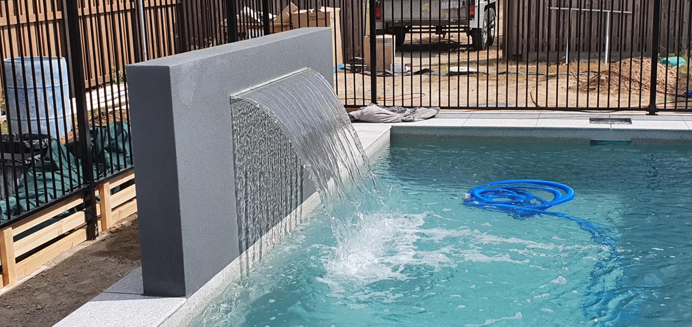 There is a Waterfall in the Middle of the Pool — NQ Tropical Pools & Renovations in Cranbrook, QLD