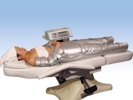 Eine Frau liegt auf einem Massagetisch mit einer Maschine darauf.