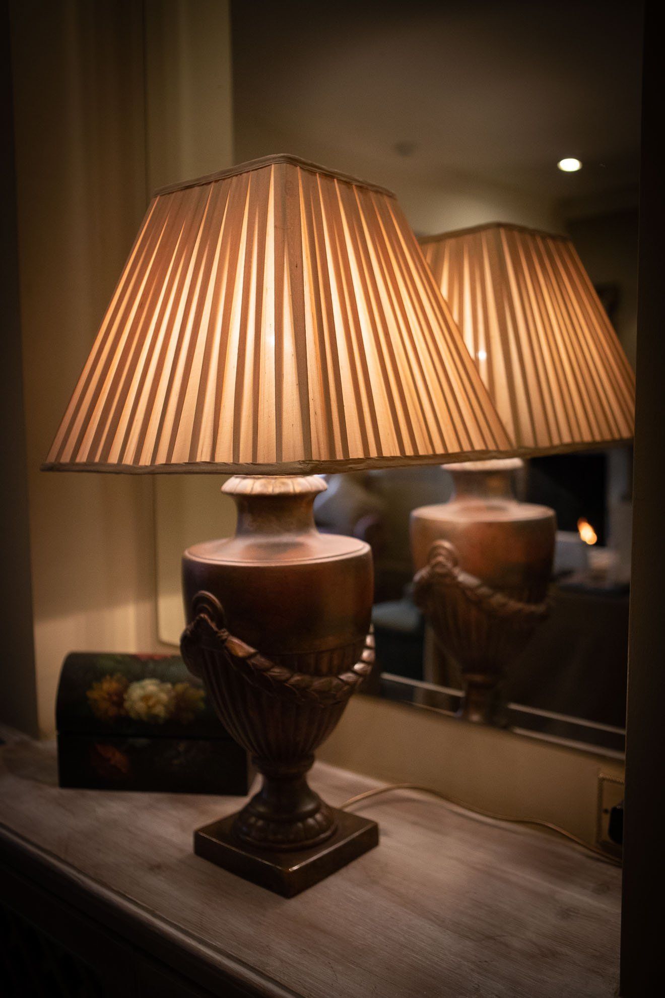 Two lamps are sitting on a table in front of a mirror.