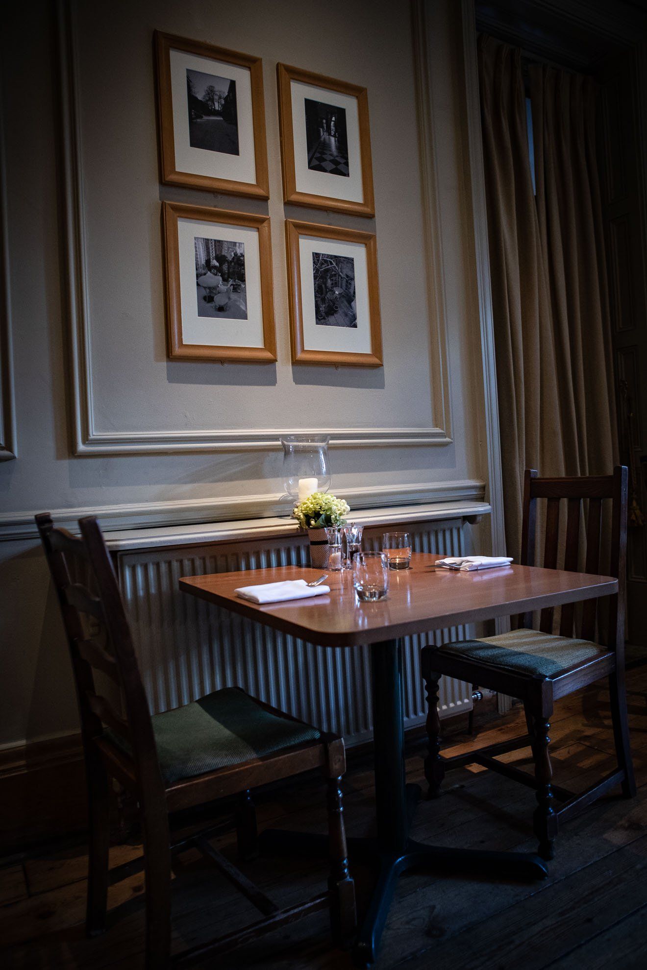 A table and chairs in a restaurant with pictures on the wall.