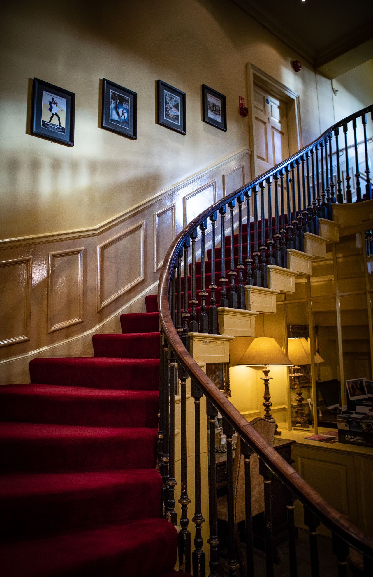 A staircase with red carpet and a wooden railing in a house.