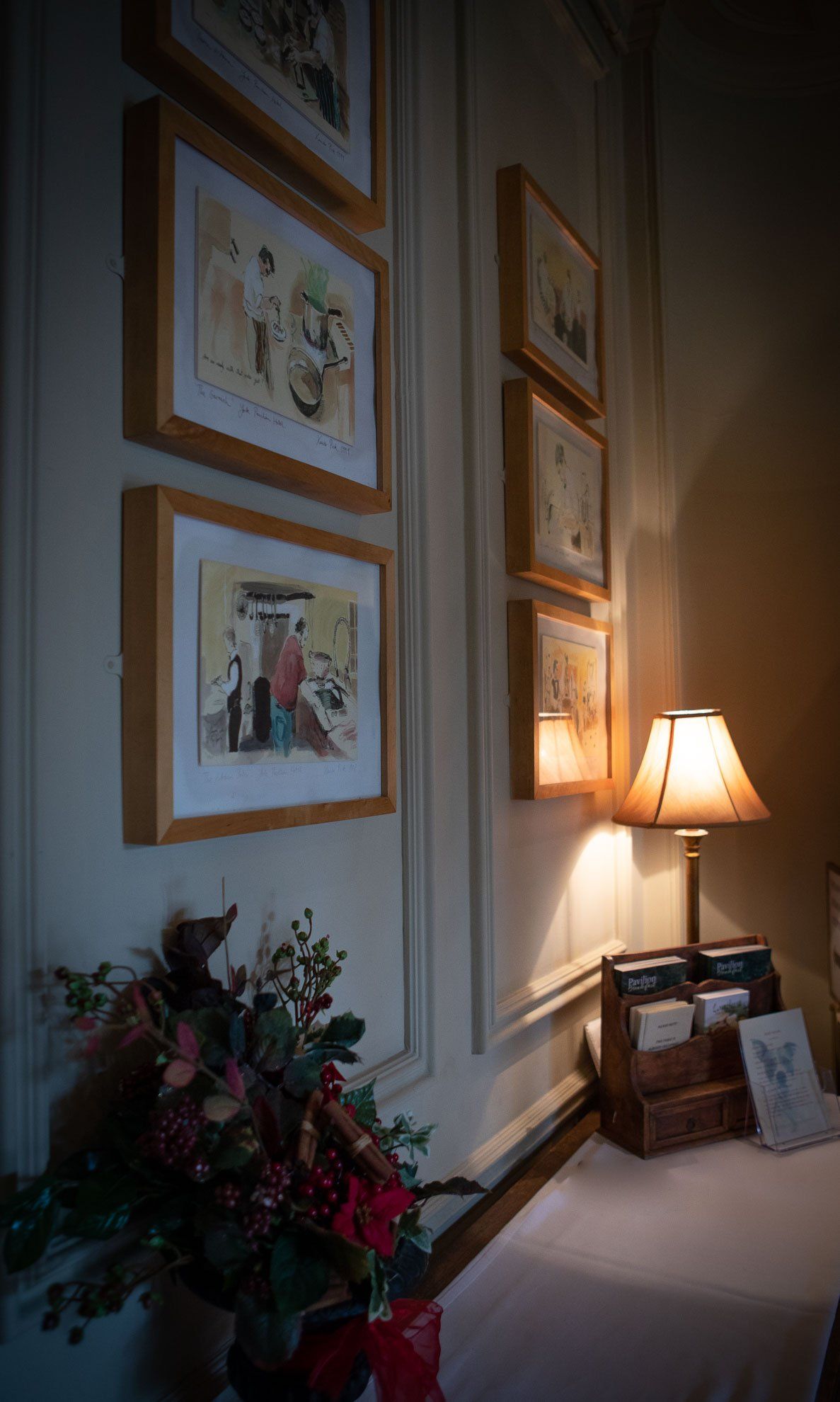 There are a lot of pictures on the wall and a lamp.
