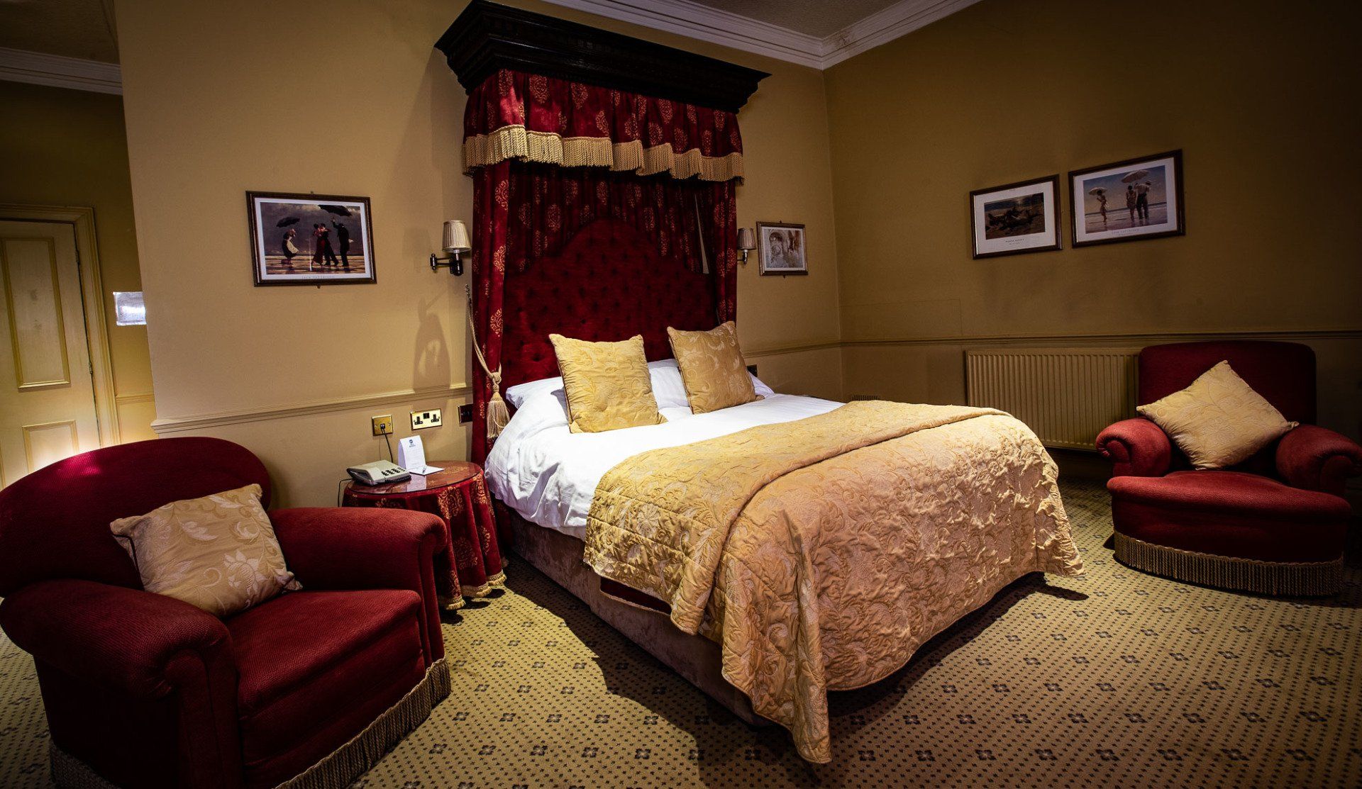 A hotel room with a bed , chairs and a canopy.