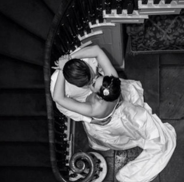 A bride and groom kissing on a spiral staircase
