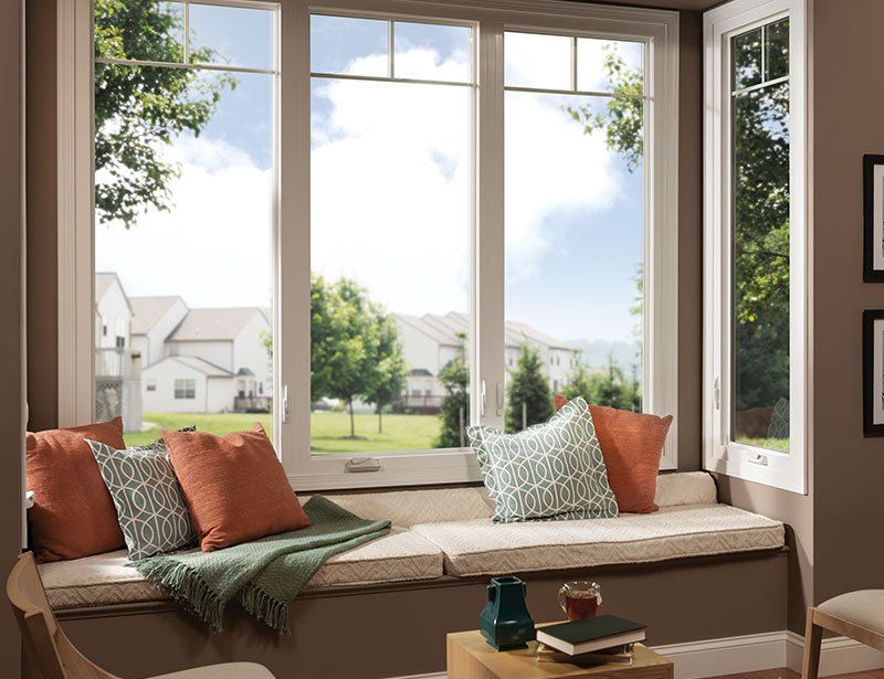 A living room with a large window and a window seat.