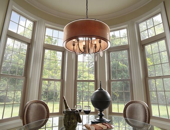 A dining room with a table and chairs and a chandelier hanging from the ceiling