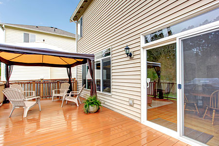 There is a deck with a gazebo and chairs on it.