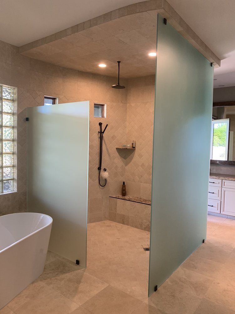 A bathroom with a walk in shower and a bathtub.