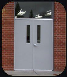 A pair of white doors on a red brick building.