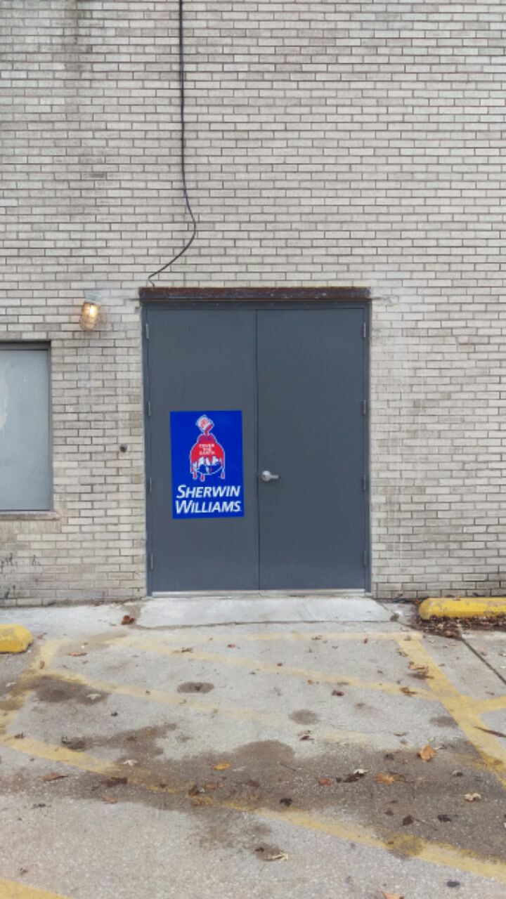 A brick building with a blue sign on the door.