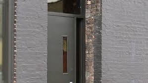 A gray brick building with a door and a window.