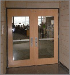 A pair of wooden doors with glass panels in a hallway
