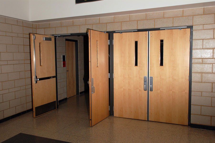 A hallway with wooden doors and a brick wall