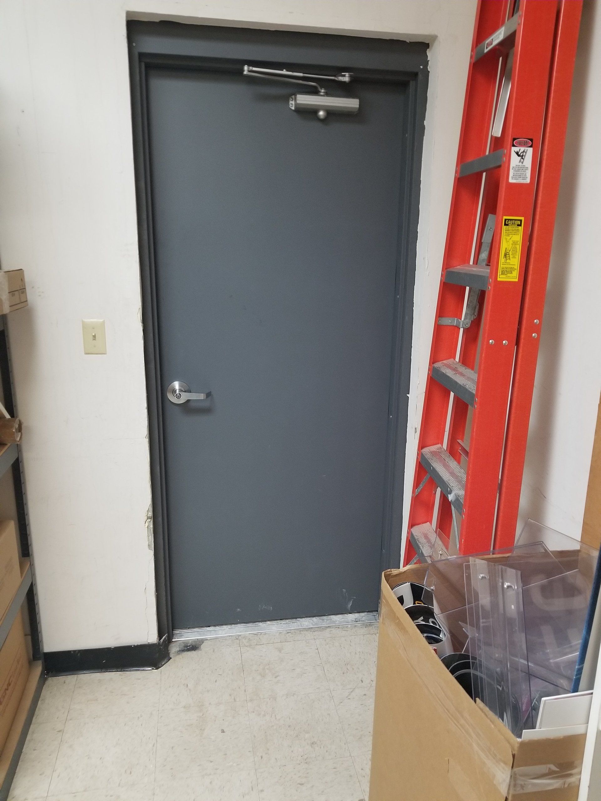 A ladder is sitting next to a door in a room.