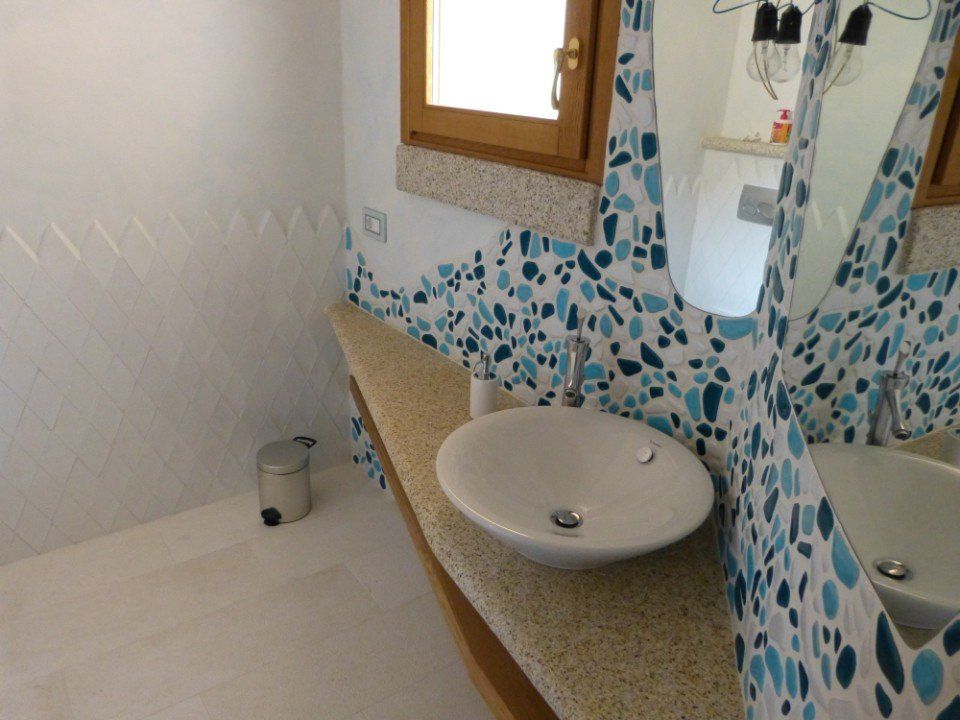 il piano in marmo di un bagno con lavandino in ceramica bianca