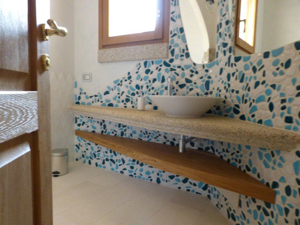 il bagno di una casa con rivestimenti a mosaico azzurro e blu
