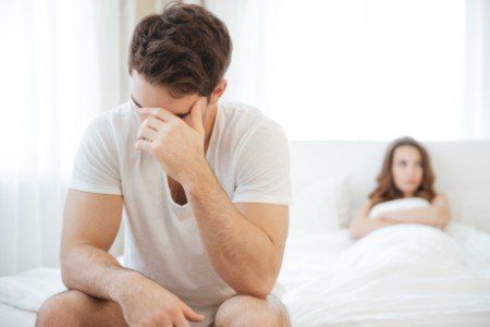 Coppia a letto con sguardi rivolti altrove