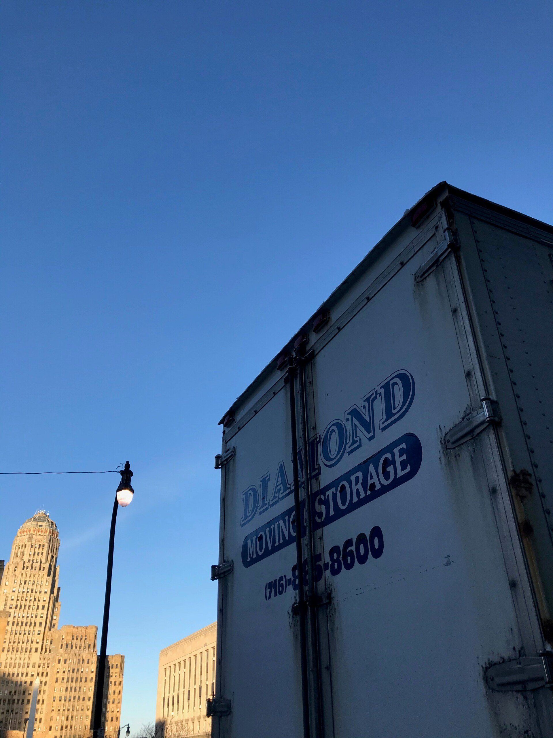 Young couple watching movers move boxes from the moving van