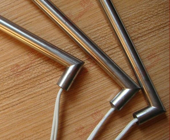 Pajitas de acero inoxidable sobre una superficie de madera, con cordones blancos sujetos a los extremos.