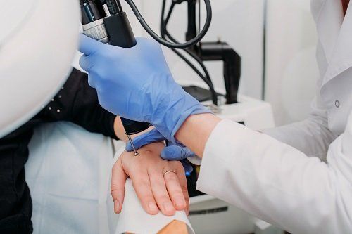 Dermatologo opera trattamento sulla mano di una paziente