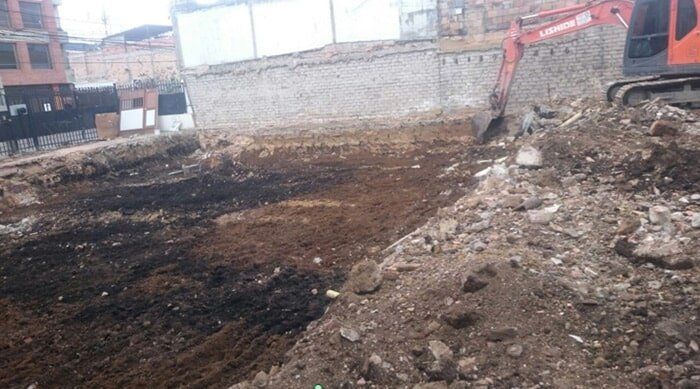 Obra en construcción accidentada y fangosa con tierra excavada