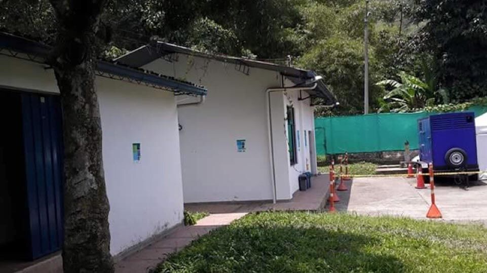 Un pequeño edificio blanco junto a un sendero cubierto de hierba