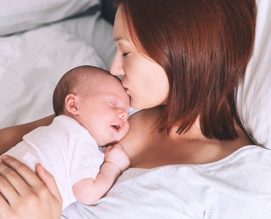Mother kissing baby.
