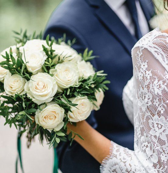 A Bride Holding A Boquete Of White Roses — Bergenfield, New Jersey — Brodericks Flowers & Gifts Inc A Bride Holding A Boquete Of White Roses — Bergenfield, New Jersey — Brodericks Flowers & Gifts Inc