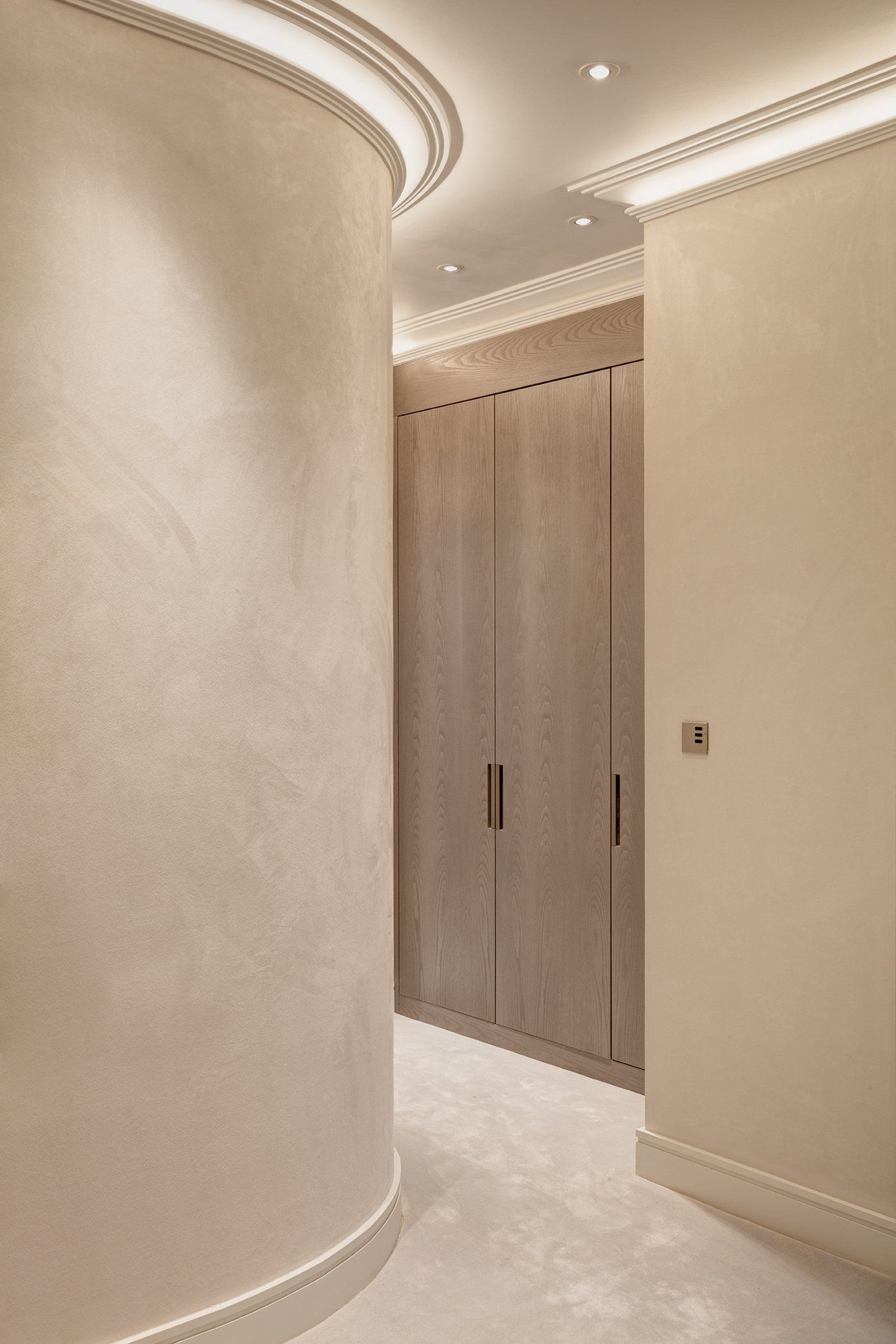 A hallway with a curved wall and a wooden door