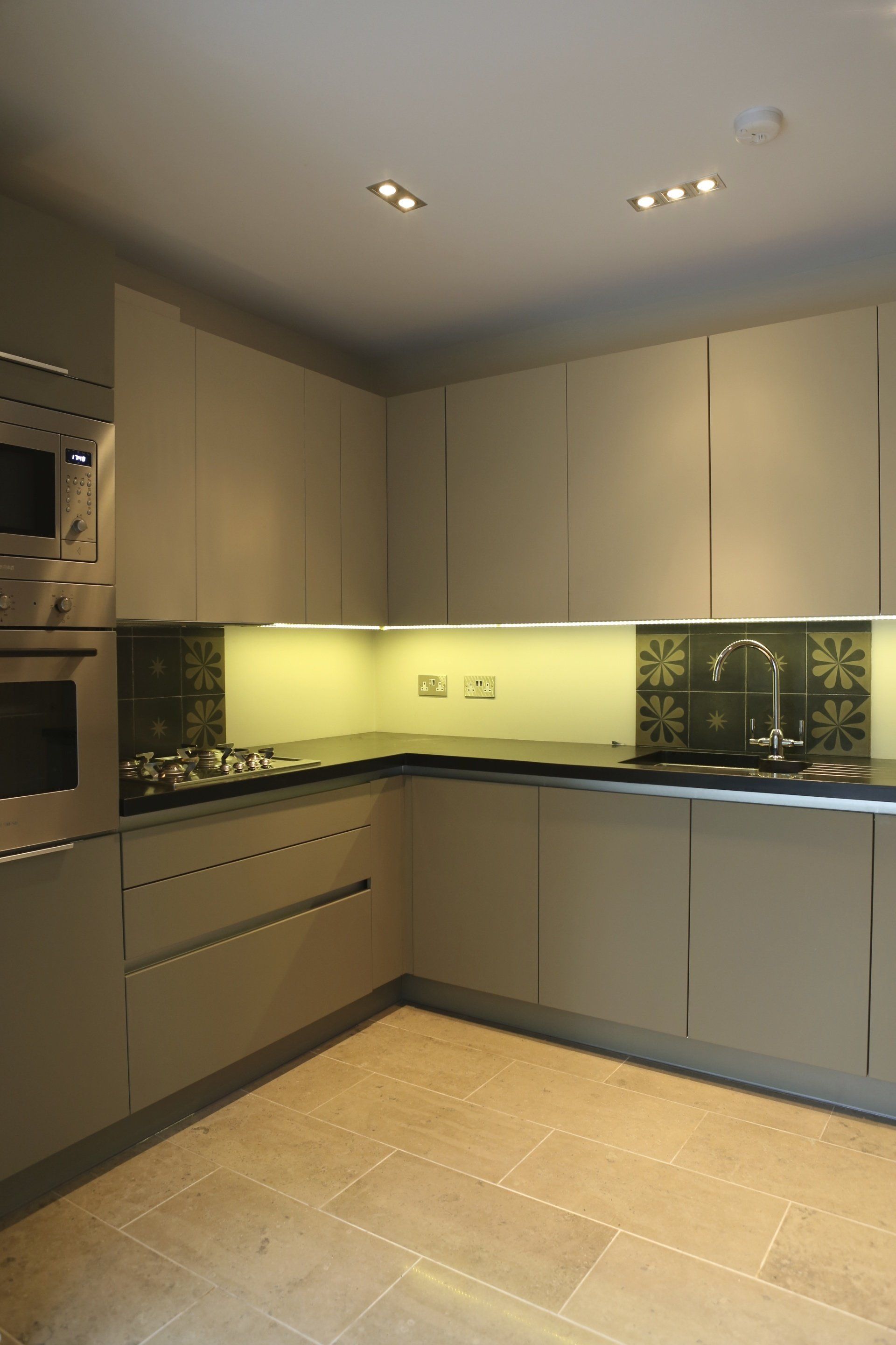 A kitchen with white cabinets and black counter tops