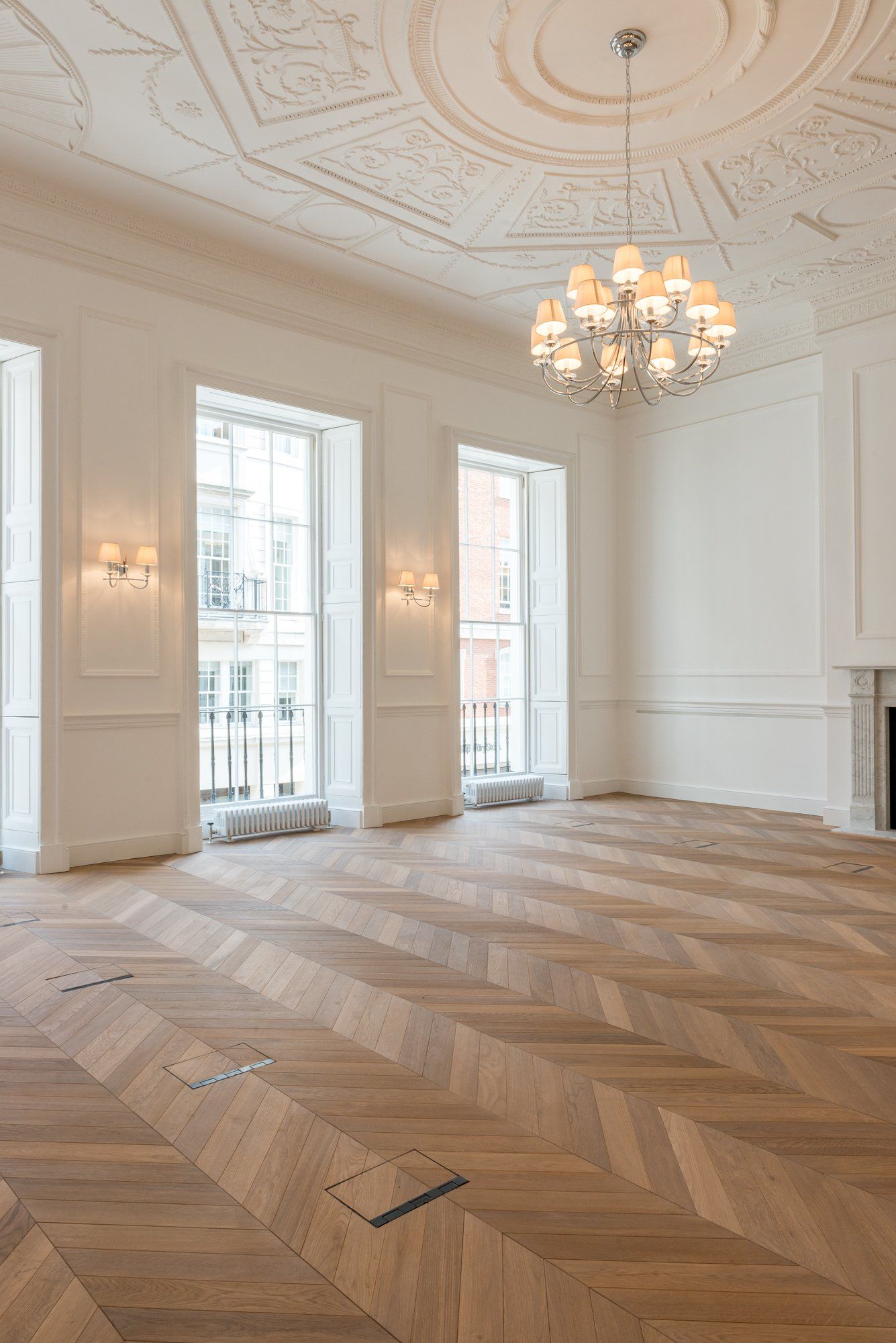 An empty room with a chandelier hanging from the ceiling