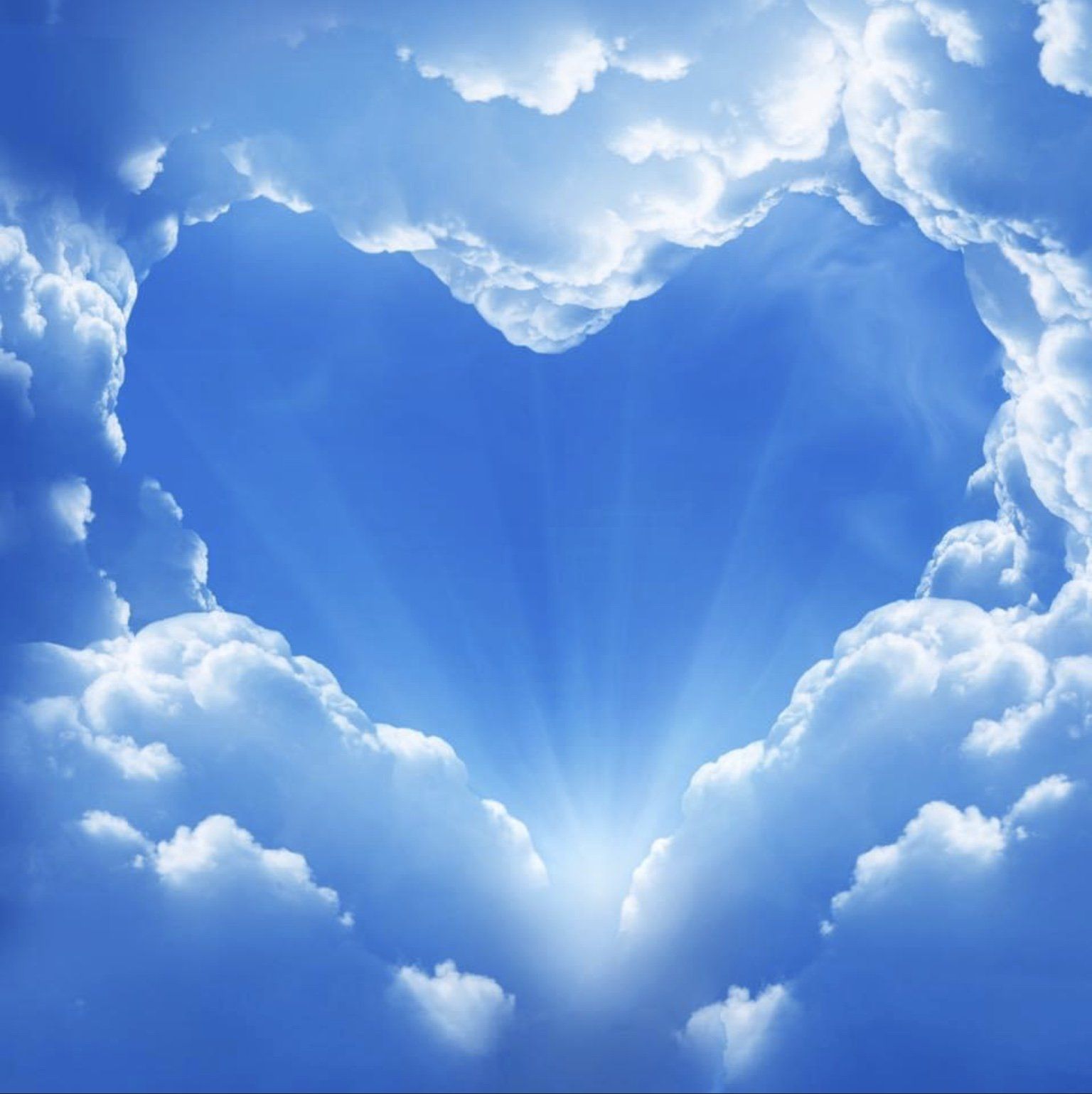 Heart-shaped opening in clouds reveals bright blue sky and sun.