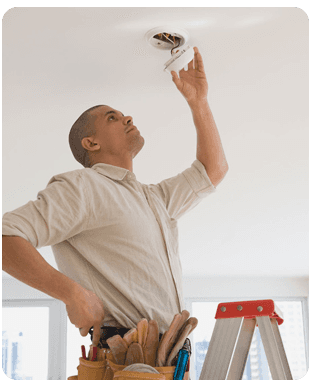 professional electrician fitting a smoke dectector