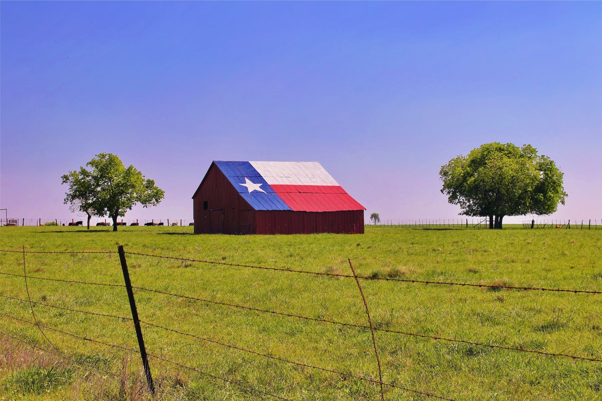 A red barn with a texas flag painted on it