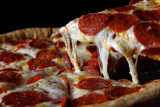 A pepperoni pizza with a slice taken out of it.