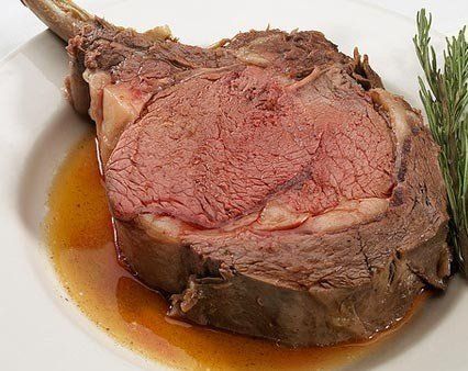 A large piece of meat is on a white plate.