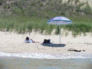 people on the beach under an umbrella
