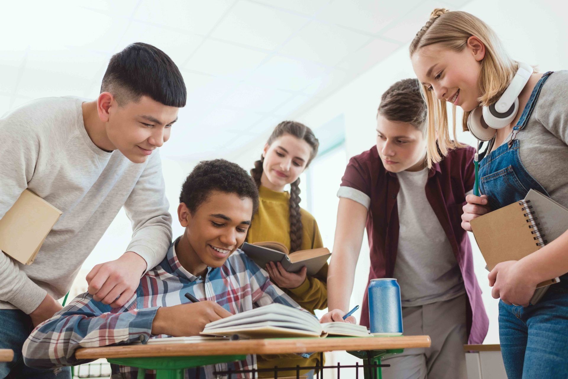 A group of young people are standing around a table in a classroom.