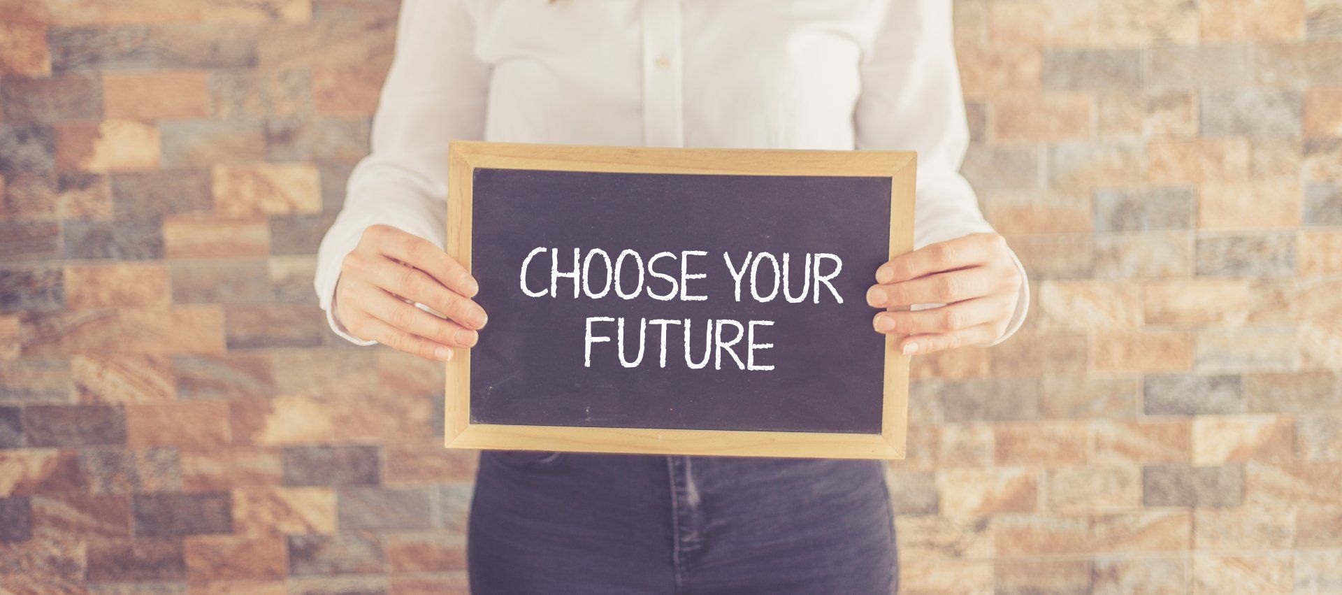 A woman is holding a chalkboard with the words `` choose your future '' written on it.