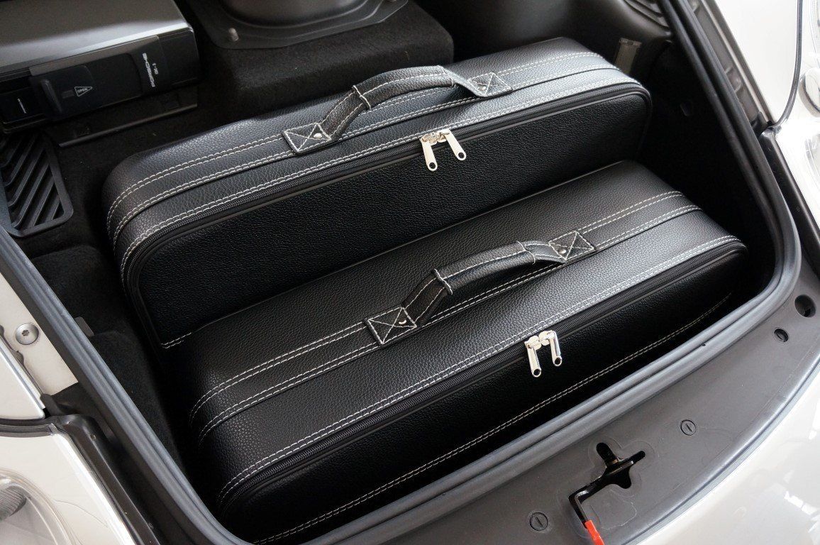 De kofferbak van een auto is gevuld met bagage en een luidspreker.